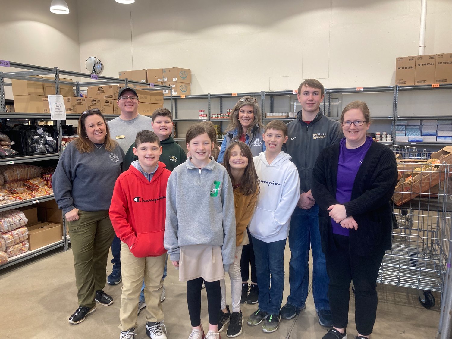 A group of fourth- through eighth-graders from St. Martin School in St. Martins conclude a Faith Families service project with staff at the Catholic Charities Center in Jefferson City. They toured the facility and then gave their time in service in the Catholic Charities Food Pantry.